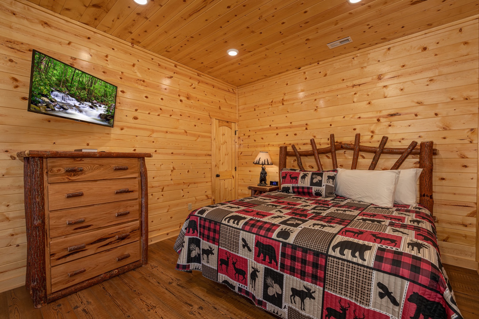 Bedroom with a king bed, dresser, and TV at Pinot Splash, a 4 bedroom cabin rental located in Gatlinburg