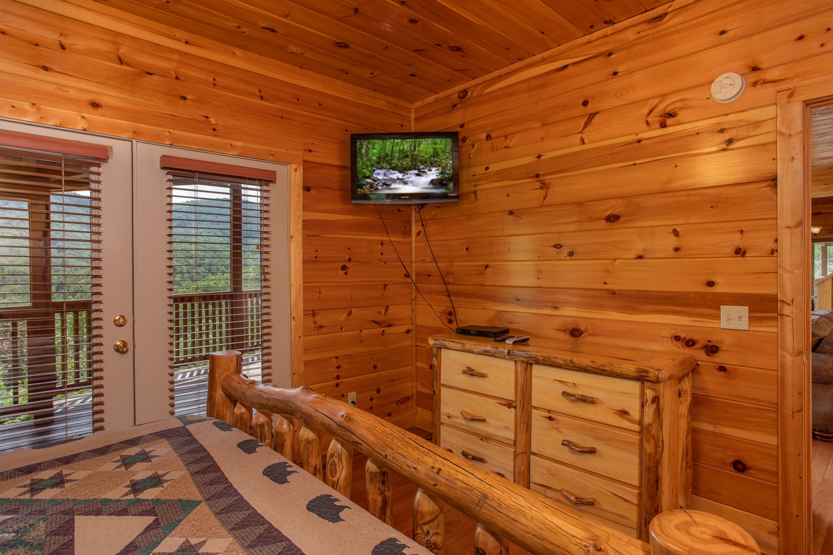 Television, dresser, and deck access in a bedroom at Four Seasons Lodge, a 3-bedroom cabin rental located in Pigeon Forge