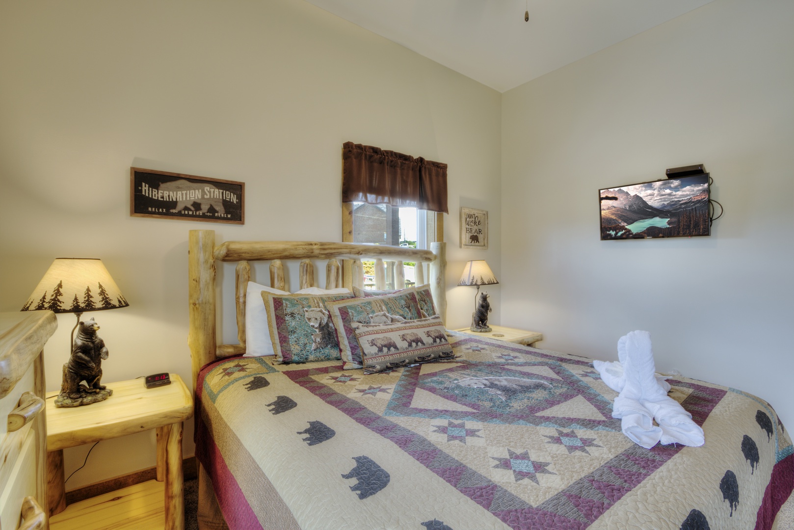 Flat screen, bedside tables, and bear lamp in bedroom at The Best View Lodge, a 5 bedroom cabin rental located in gatlinburg