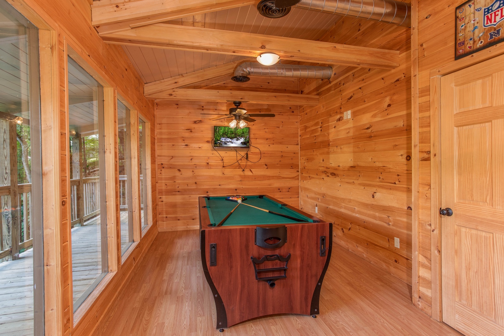 Pool table in a room with lots of natural light on the deck at License to Chill, a 3 bedroom cabin rental located in Gatlinburg