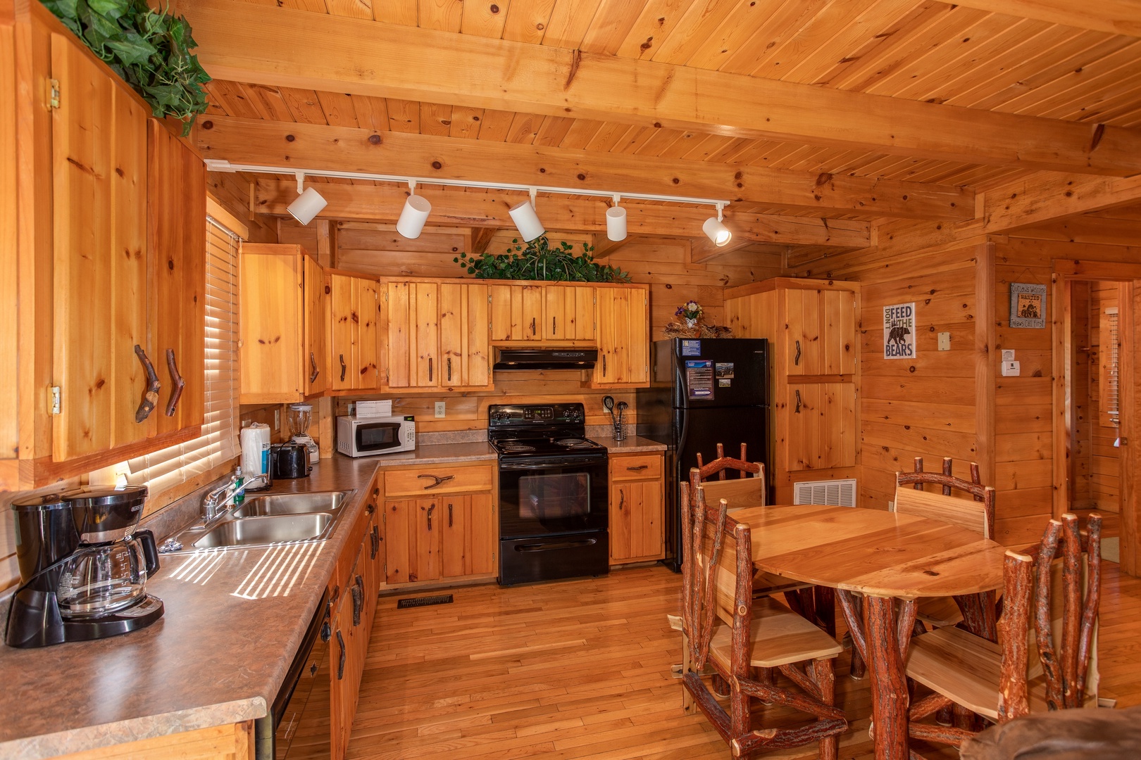 Dining table for four in the kitchen with black appliances at Dreams Do Come True, a 1-bedroom cabin rental located in Pigeon Forge