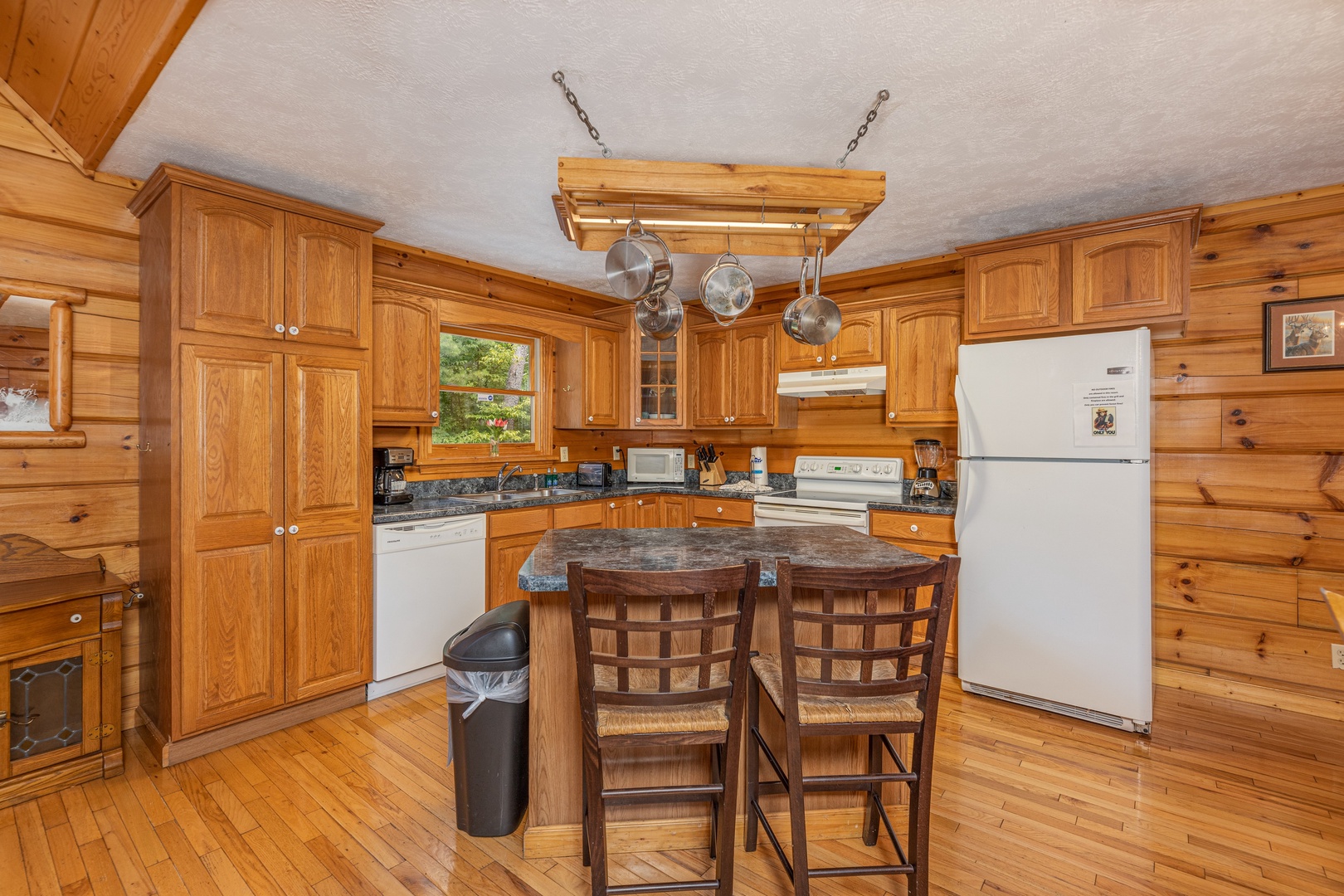 Breakfast bar for two in a kitchen with white appliances at Wildlife Retreat, a 3 bedroom cabin rental located in Pigeon Forge