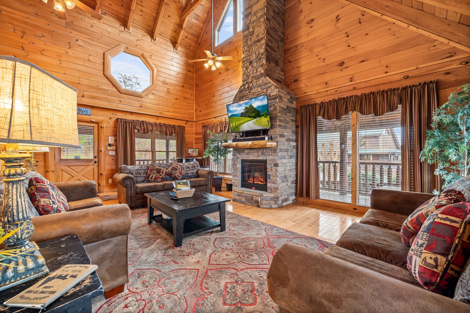 Living room seating with vaulted ceiling, tall fireplace, and TV at Better View, a 4 bedroom cabin rental located in Pigeon Forge