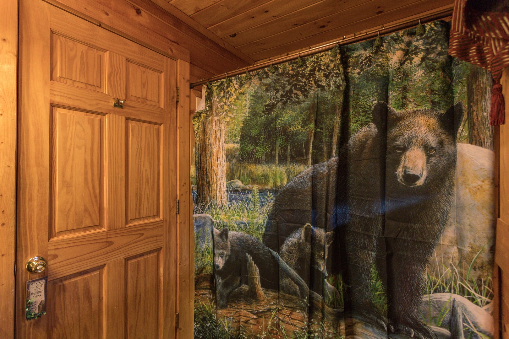 Bathroom with a tub and shower and black bear decor at Hibernation Station, a 3-bedroom cabin rental located in Pigeon Forge