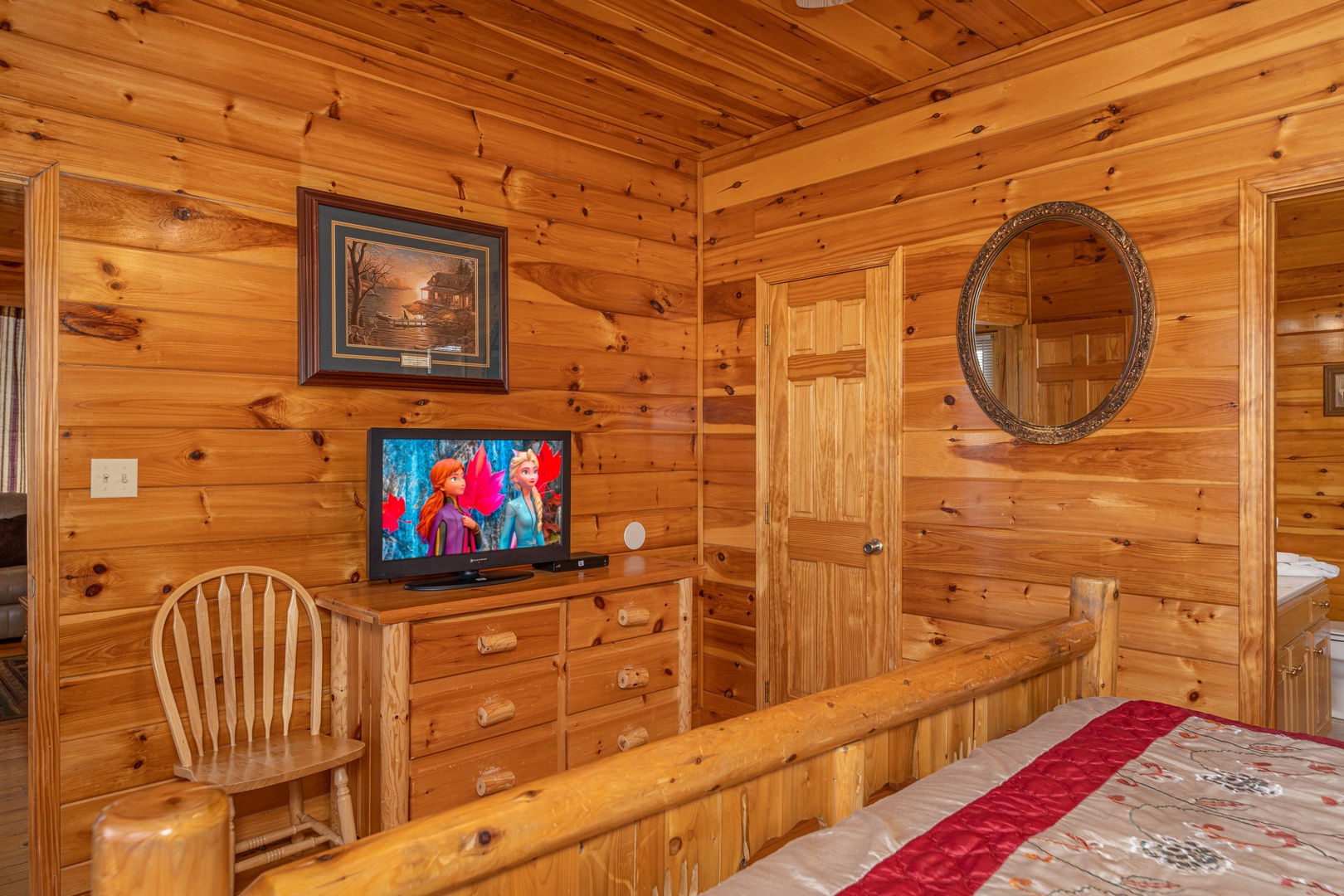 Dresser, TV, and chair in a bedroom at Hickernut Lodge, a 5-bedroom cabin rental located in Pigeon Forge