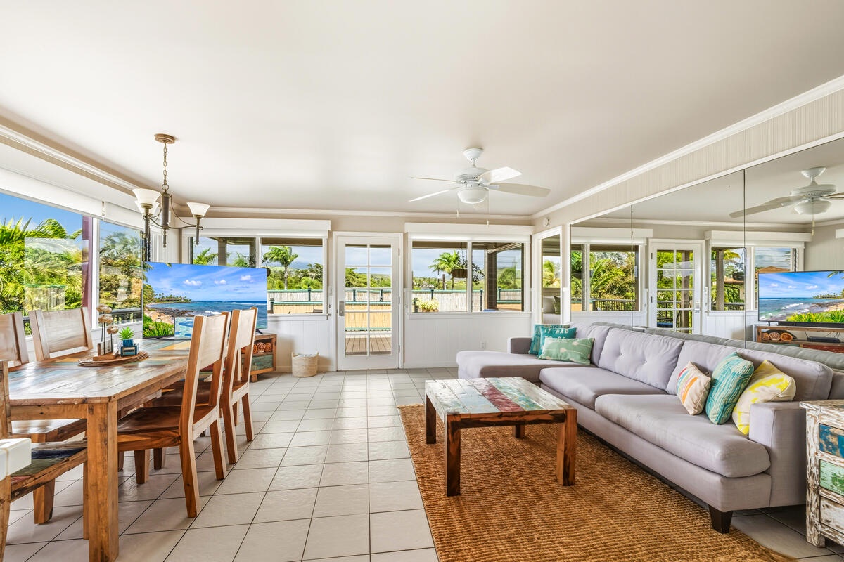 Relax in your bright living space where colorful pillows invite comfort and ocean breezes flow through expansive windows.