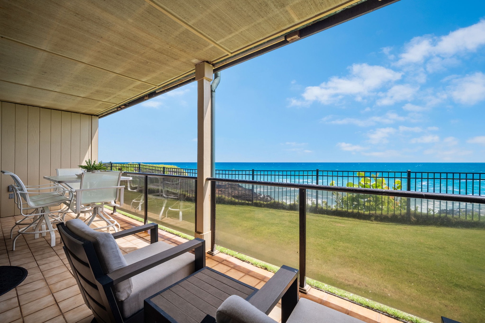 Expansive ocean views stretch across your private balcony, where comfortable seating and dining space invite you to relax and soak in the stunning coastal scenery.