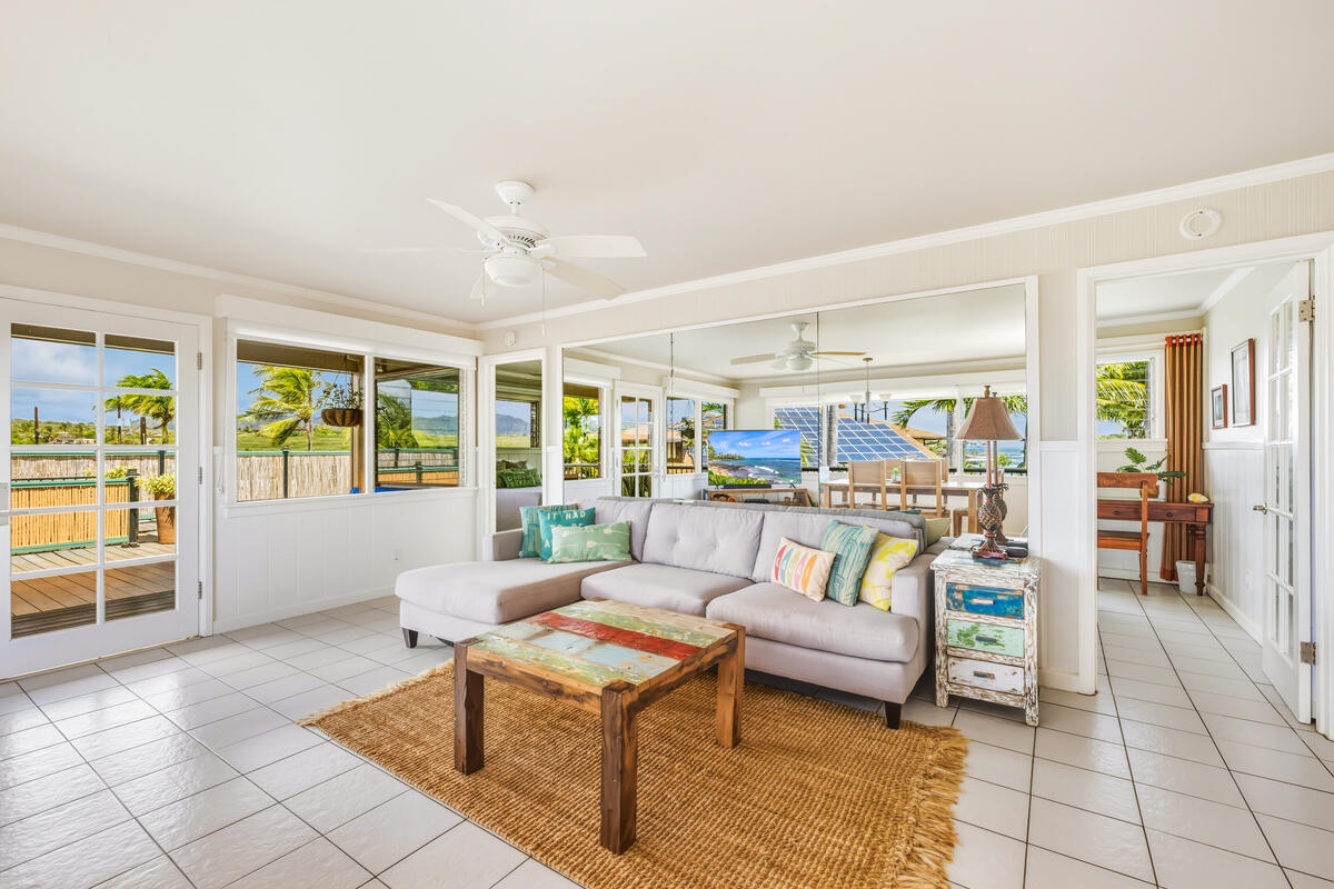 Unwind in your bright living space where ocean breezes flow through open windows and tropical views create the perfect beach house atmosphere.