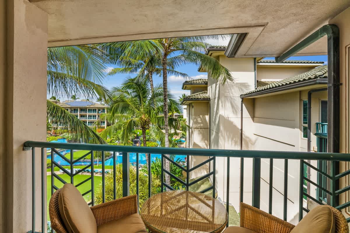 Your private balcony offers views of swaying palms, vibrant gardens, and the sparkling pool below—a perfect spot to unwind with morning coffee or evening breezes.