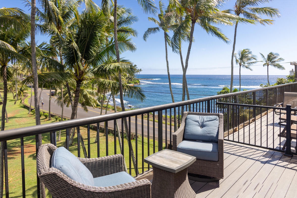 Unwind on your private balcony with plush seating while soaking in breathtaking ocean views through swaying palm trees.