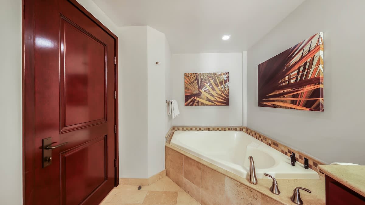 Sink into the deep tub after a day of exploring, surrounded by warm wood tones and tropical art that brings the island indoors.