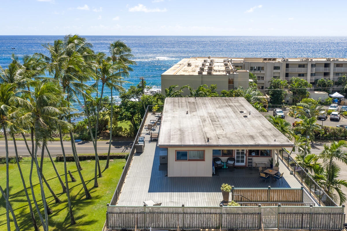 Beachfront property with stunning ocean views, surrounded by swaying palms and tropical landscaping in a prime coastal location.
