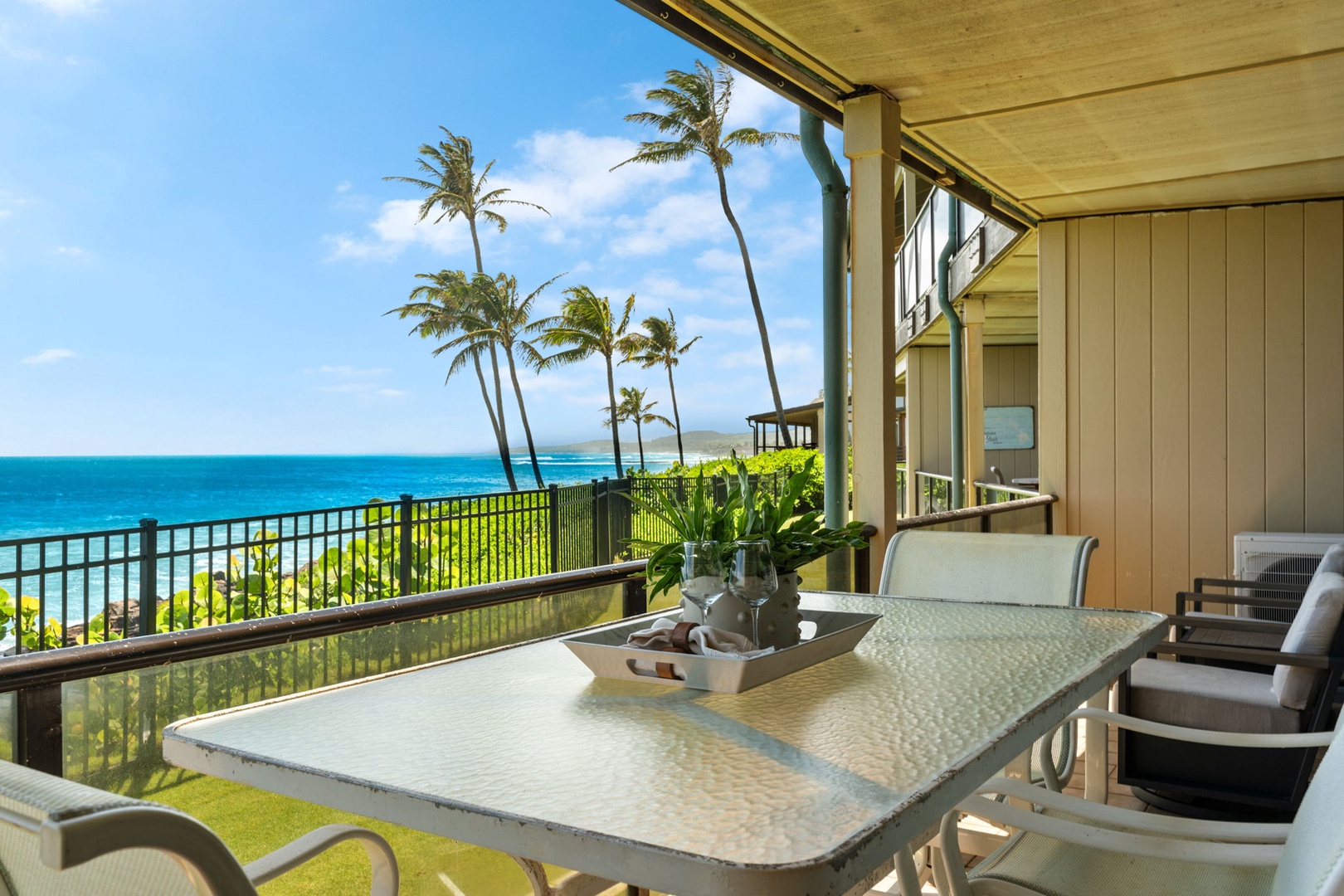 Sip your morning coffee while gazing at turquoise waters and swaying palms from this stunning oceanfront lanai. The gentle tropical breeze and panoramic sea views create your perfect island escape.