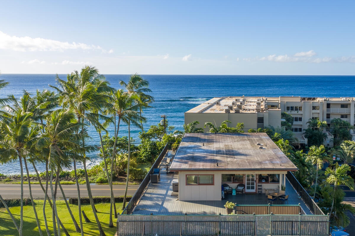 Beachfront property nestled among swaying palms with crystal blue ocean views and tropical landscaping in a peaceful coastal setting.