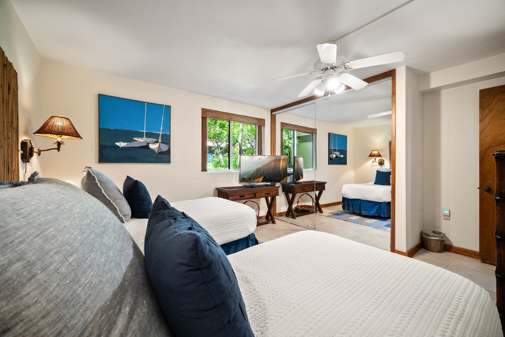 Sink into plush bedding in this light-filled retreat, where coastal artwork sets a serene tone. Your peaceful sanctuary flows into a cozy sitting area with garden views just beyond.