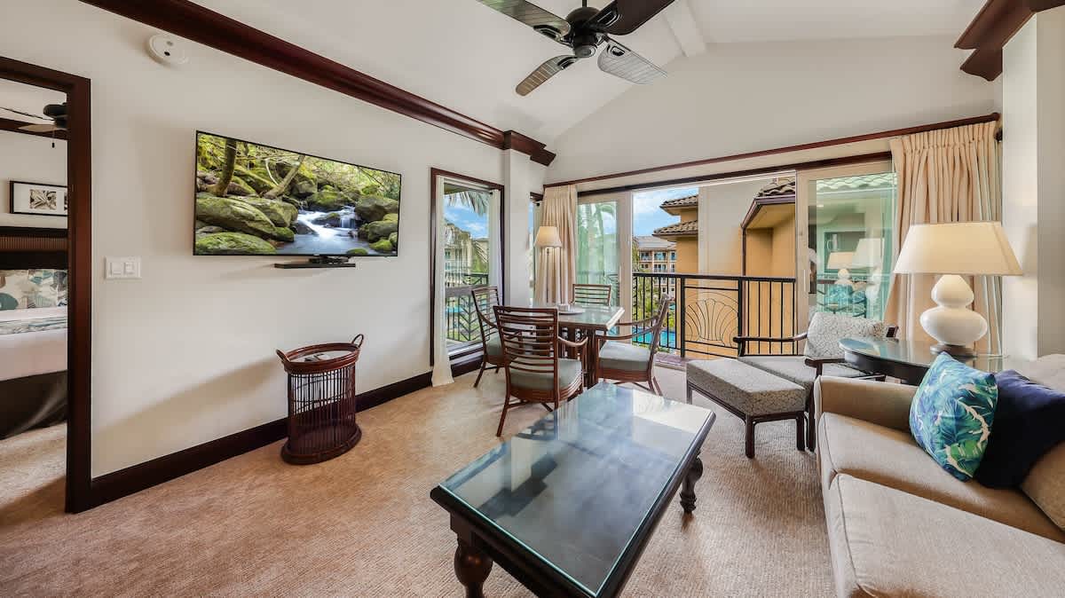 Unwind in your spacious living area where natural light pours through sliding doors to your private balcony with tranquil pool views. Elegant furnishings and thoughtful touches create your perfect retreat.