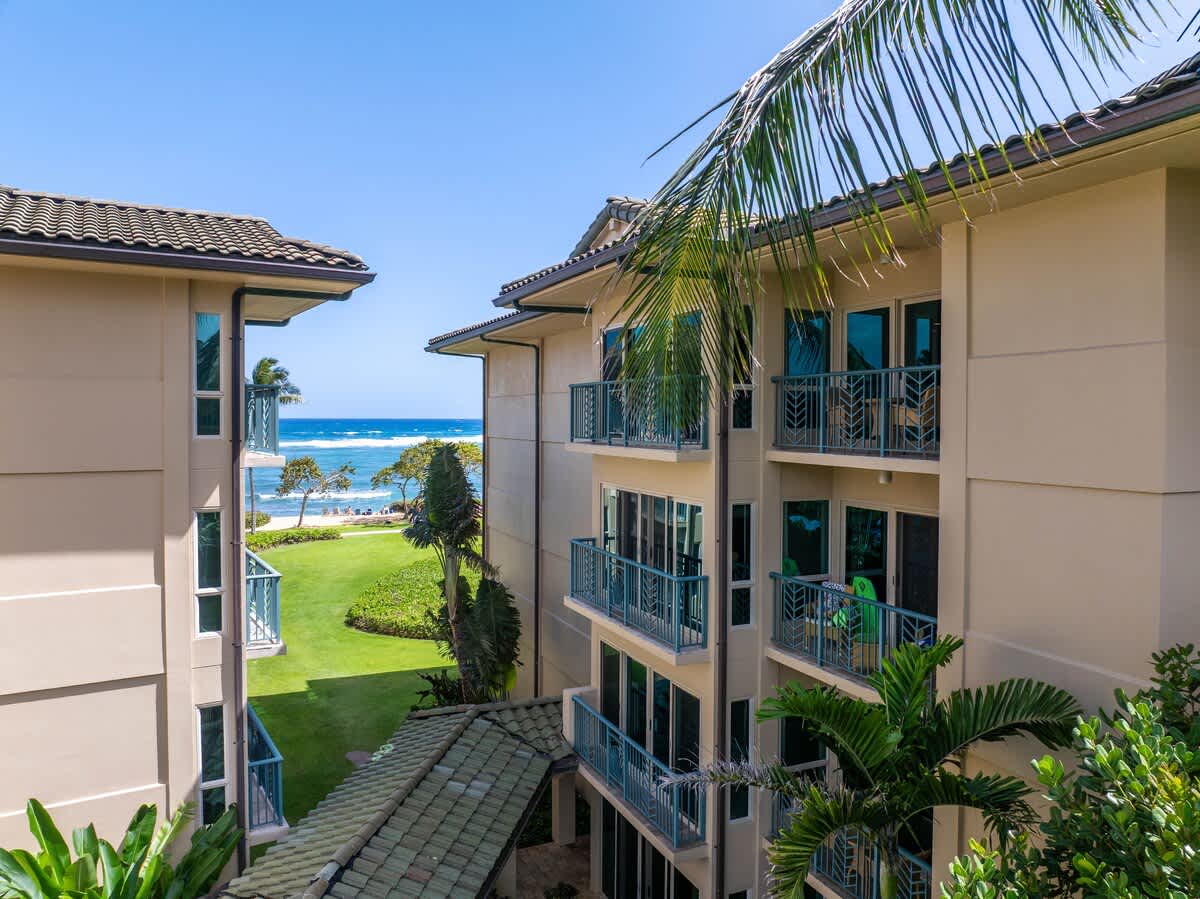 Multi-level beachfront property featuring lush landscaped grounds with direct ocean access and tropical vegetation throughout the exterior areas.