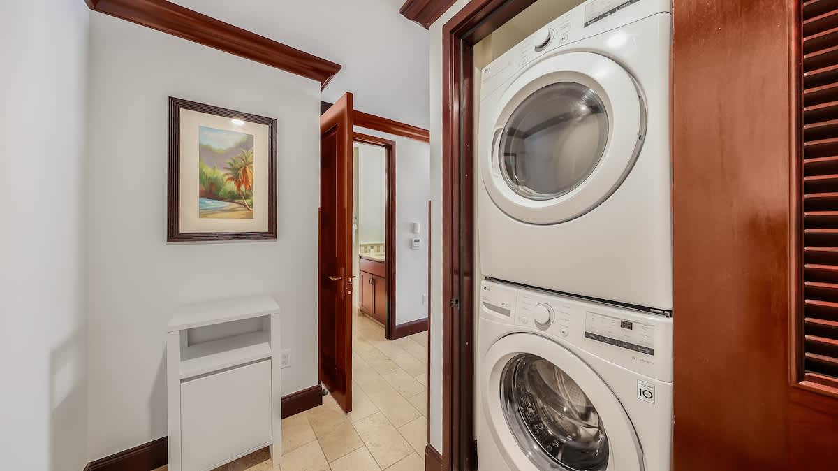 Your own in-unit laundry nook makes it easy to refresh clothes anytime, with a full-size washer and dryer stacked neatly behind a beautiful wooden door—convenience that feels like home.