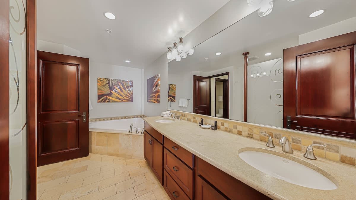 Indulge in your private spa-like bathroom with a soaking tub, dual vanities with ample storage, and elegant tile accents—perfect for unwinding after a day of exploring.