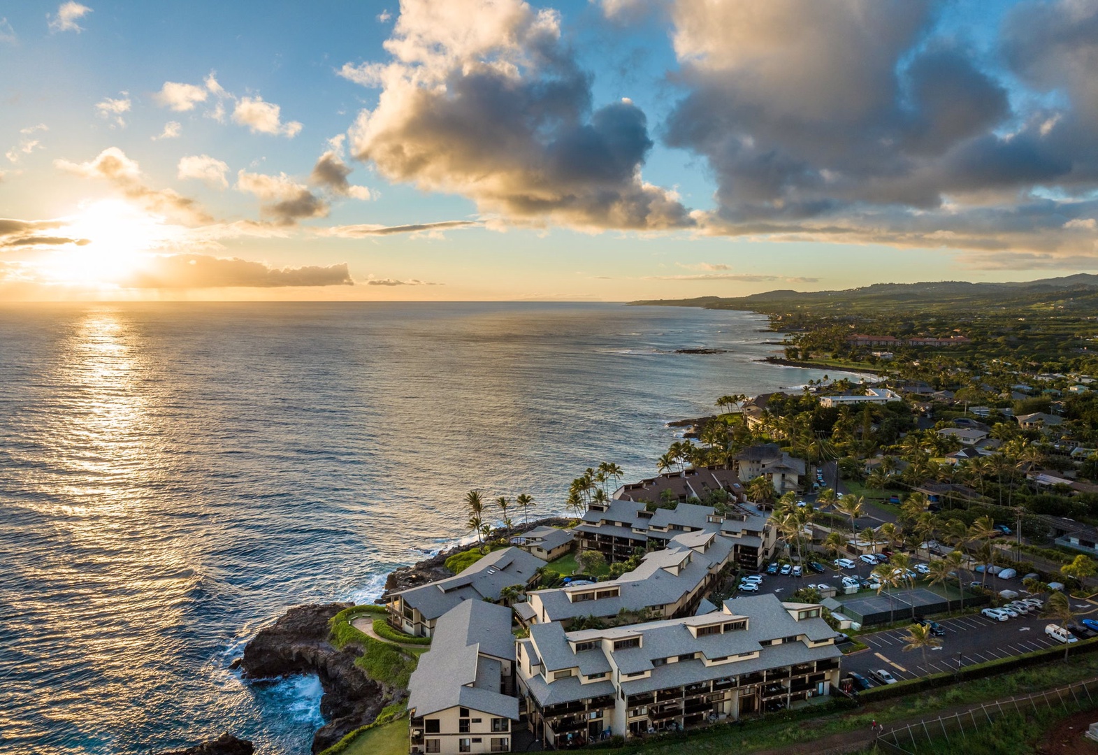 Aerial view of the oceanfront property at sunset, showcasing the coastal location and dramatic sky over the Pacific shoreline.