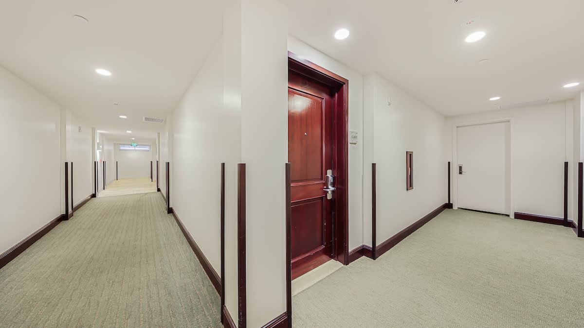 A well-lit hallway with elegant wood accents leads to your private entrance, offering a clean and welcoming path to your home away from home.