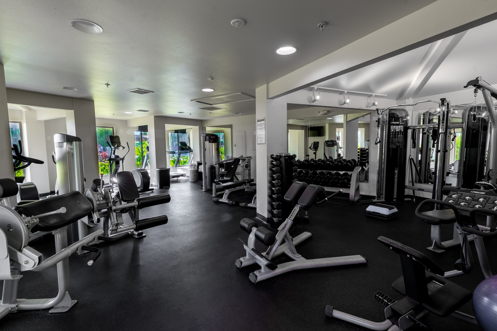 Stay active during your vacation in this well-equipped fitness center, featuring modern cardio machines, free weights, and strength training equipment. Bright natural light and mirrored walls create an energizing workout space.