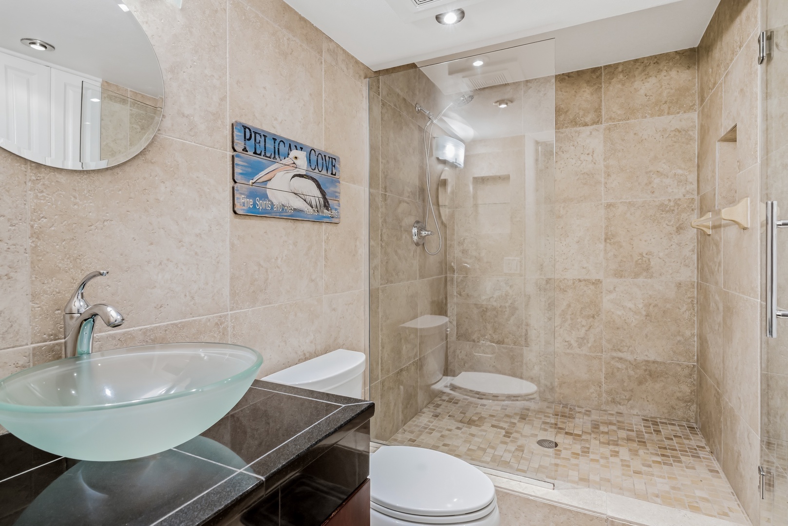 Your spa-like bathroom features a walk-in shower with soothing beige tones, modern glass vessel sink, and coastal decor that whispers relaxation after beach days.