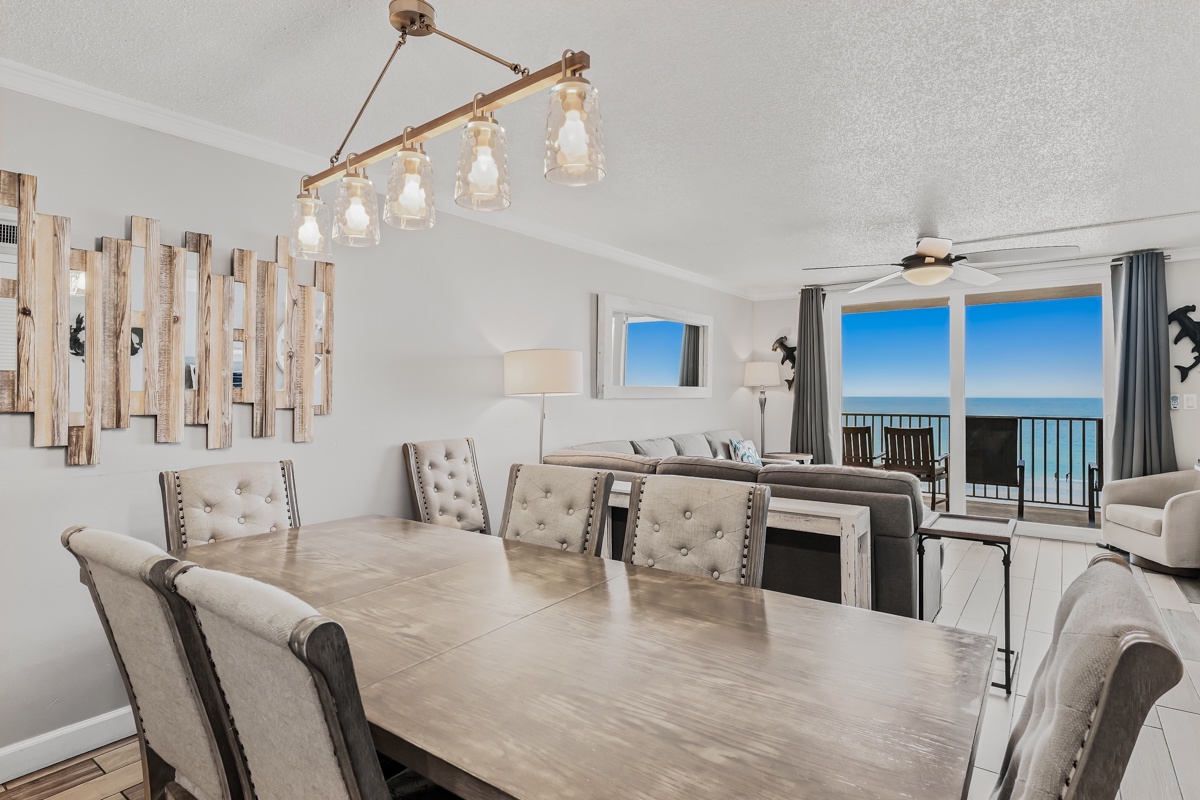 Gather around the elegant dining table where coastal charm meets modern comfort, with ocean breezes and stunning sea views greeting you through glass doors that open to your private balcony.