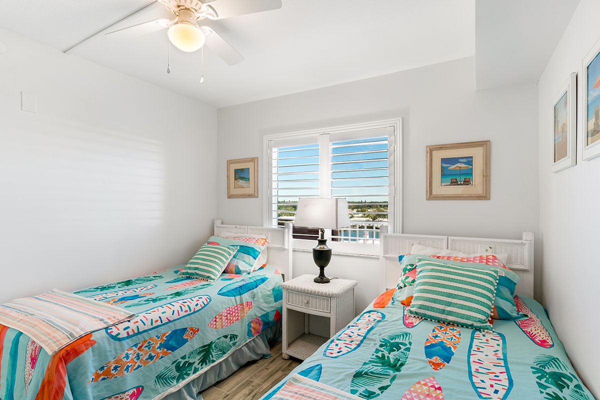Two twin beds with cheerful tropical bedding create the perfect space for you to rest after beach adventures.