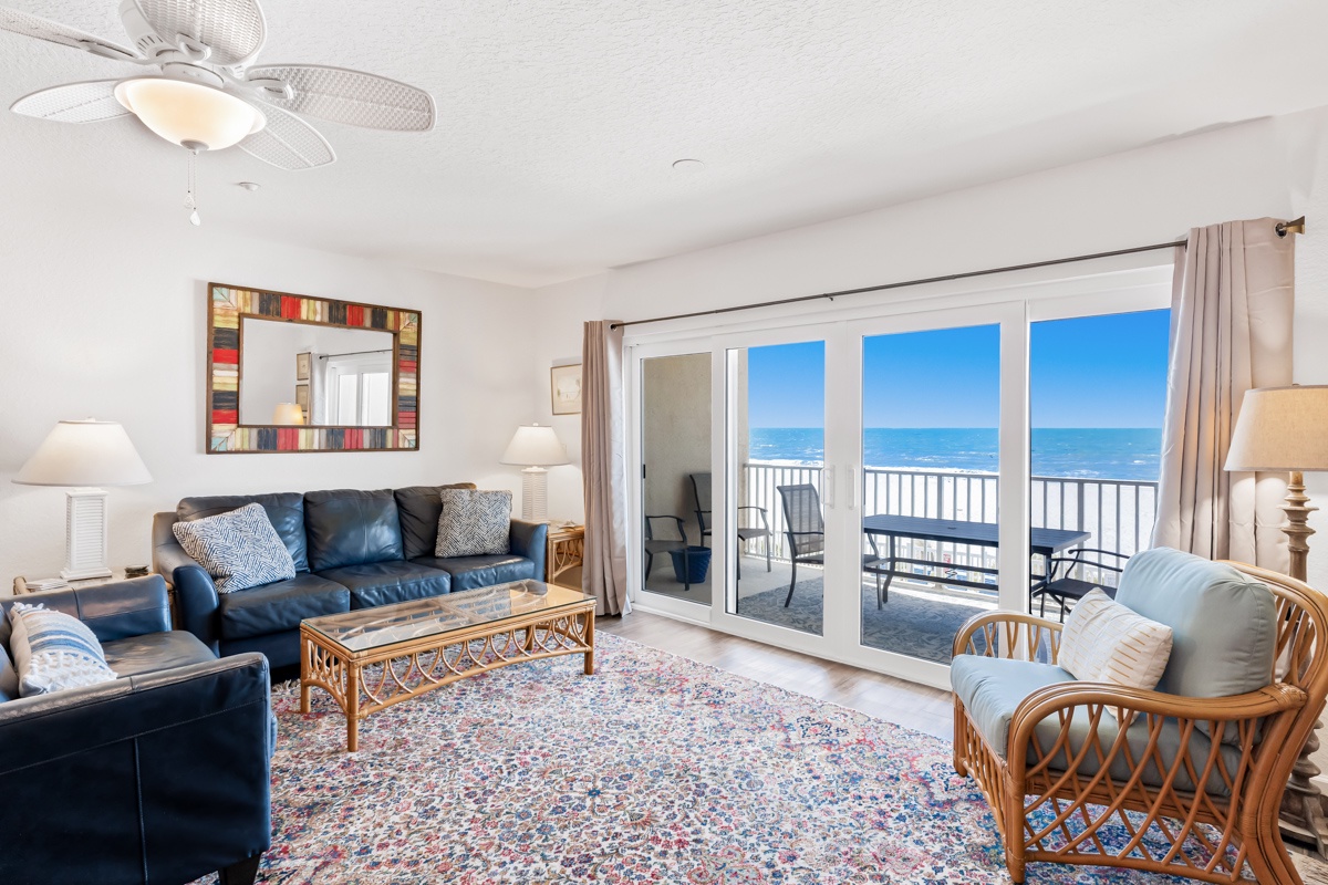 Relax in your coastal living room where ocean breezes flow through open doors and endless sea views create the perfect backdrop for vacation memories.