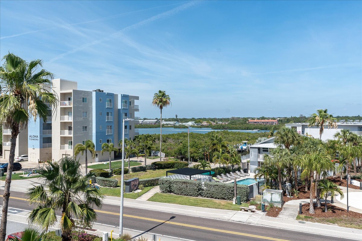 Modern waterfront property set among swaying palms with bay views and a refreshing pool area in a coastal neighborhood.