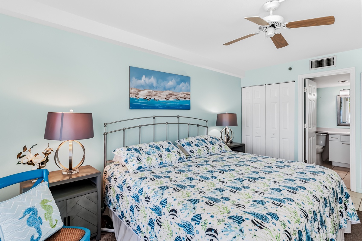 Slip into your coastal retreat, where soft blues and crisp linens invite you to unwind. A gentle ceiling fan stirs the breeze, while your spacious closet keeps everything tucked away. Your private bath is just steps away—relax and breathe easy here.