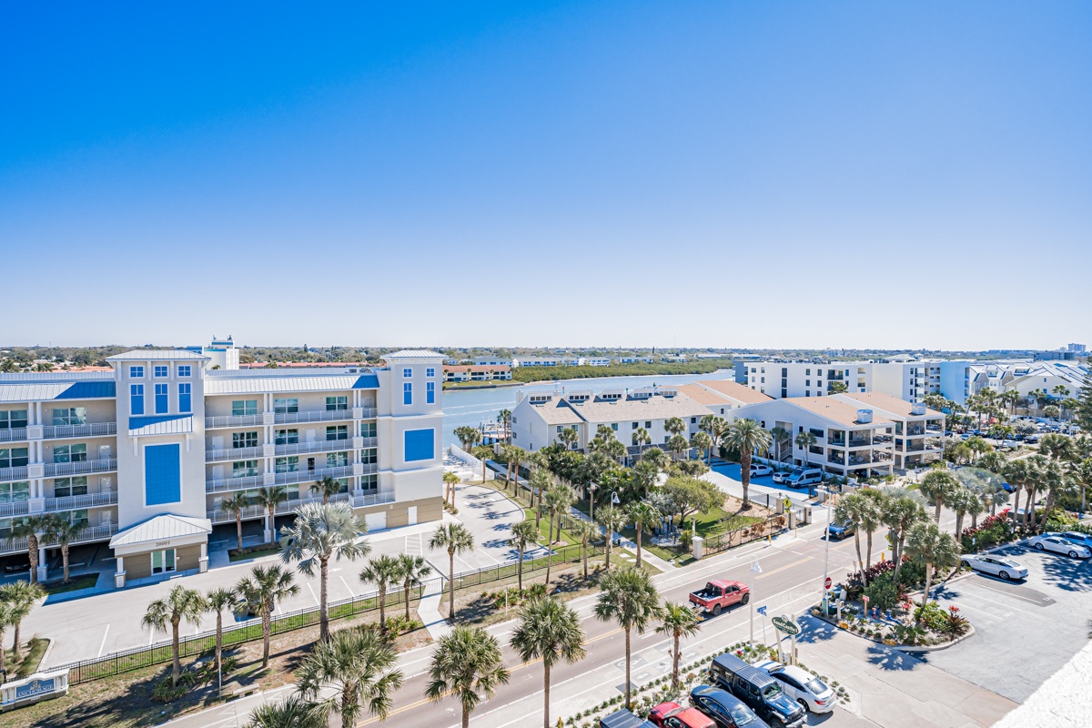 Modern coastal resort complex featuring multiple buildings with tropical landscaping and convenient parking areas.