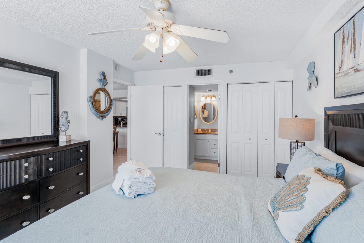 Drift off to peaceful sleep in your coastal-inspired bedroom with plush bedding, nautical touches, and refreshing ceiling fan breeze.