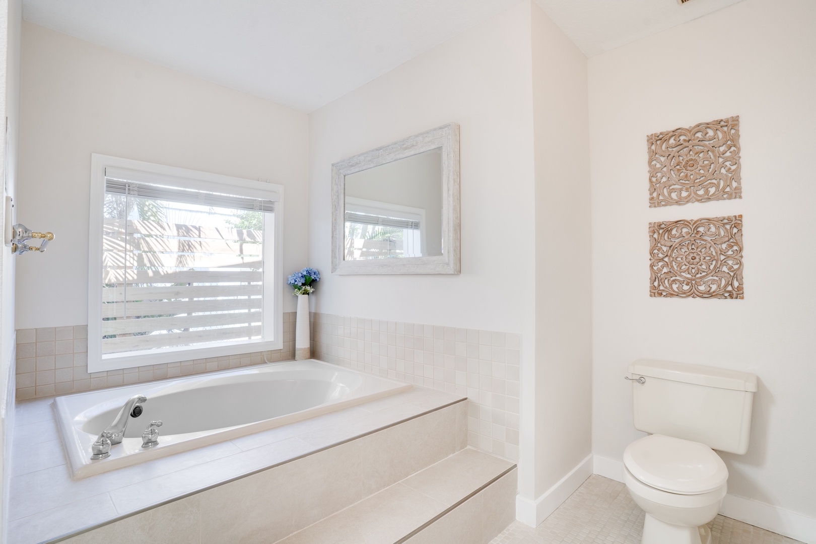 Unwind in your serene bathroom sanctuary with elegant carved wall art and a spacious soaking tub perfect for relaxation.