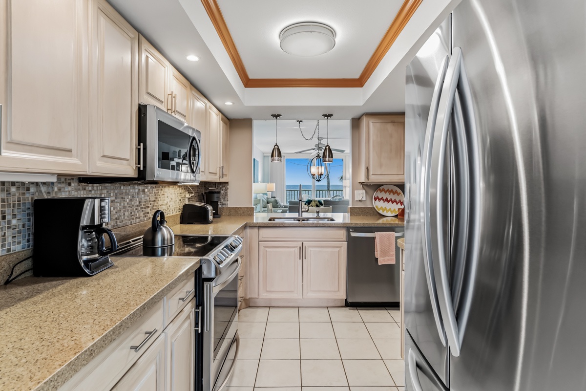 Step into your fully-equipped kitchen where everything you need to cook and gather is at your fingertips, from stainless-steel appliances to warm wood-accented ceilings that make this space feel both polished and inviting.