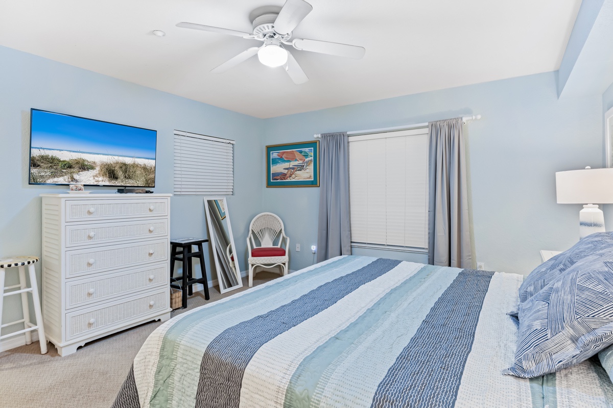 Your coastal bedroom features ocean-themed décor, a comfy bed with striped linens, and entertainment for peaceful evenings by the shore.