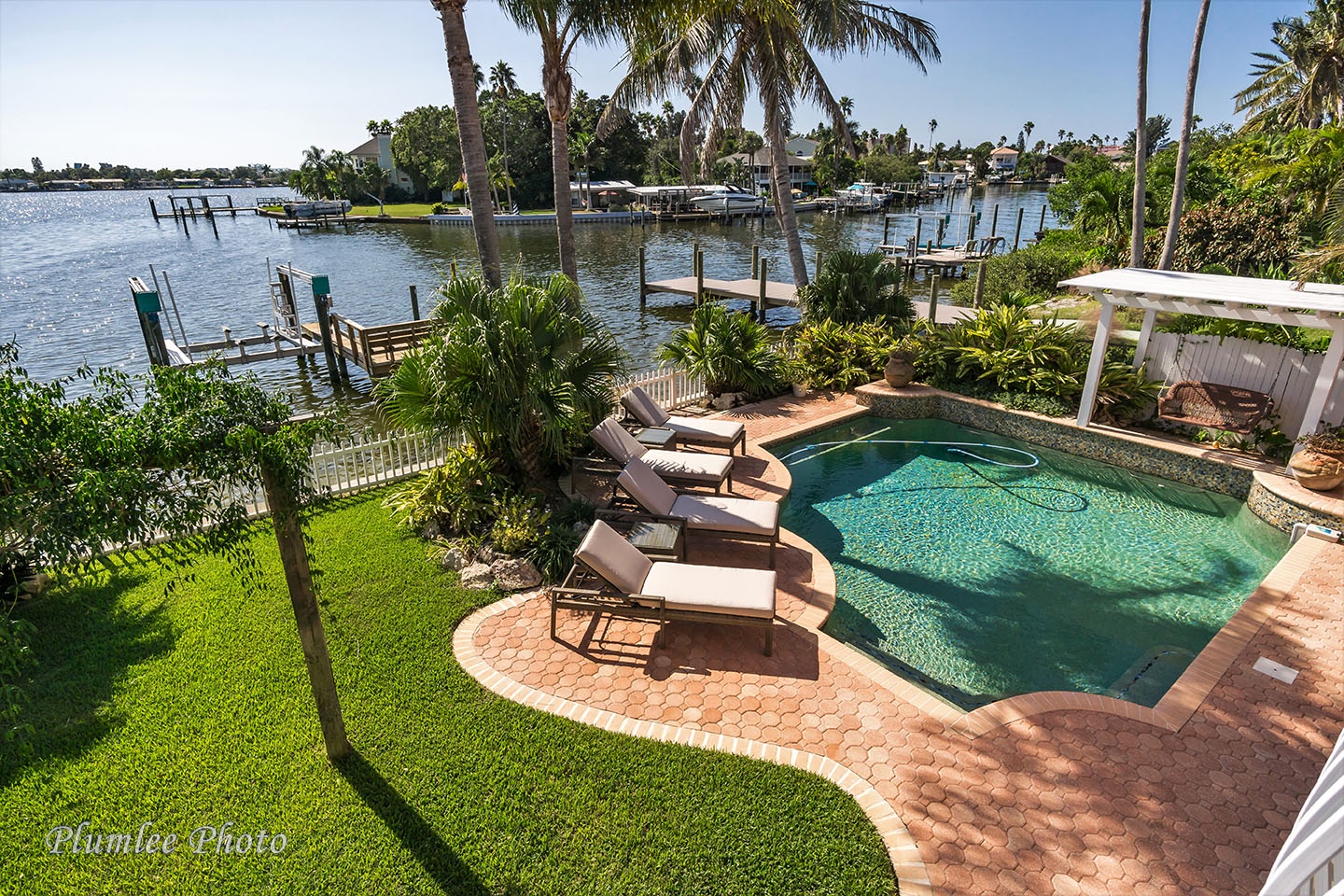 Blue water, green space, and a dock.