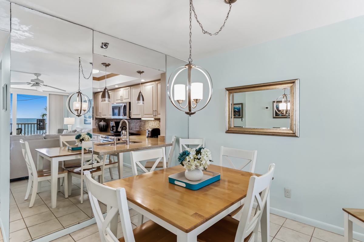 Gather around this inviting dining space where your meals are framed by coastal charm and open sightlines to the kitchen and ocean beyond. Bright, breezy, and perfect for your morning coffee or evening feast.