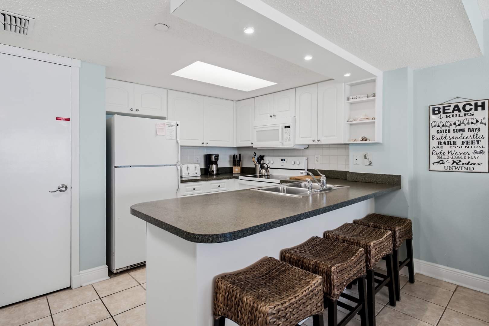 Your coastal retreat features a fully equipped kitchen with modern appliances and a spacious breakfast bar—perfect for morning coffee or casual meals.