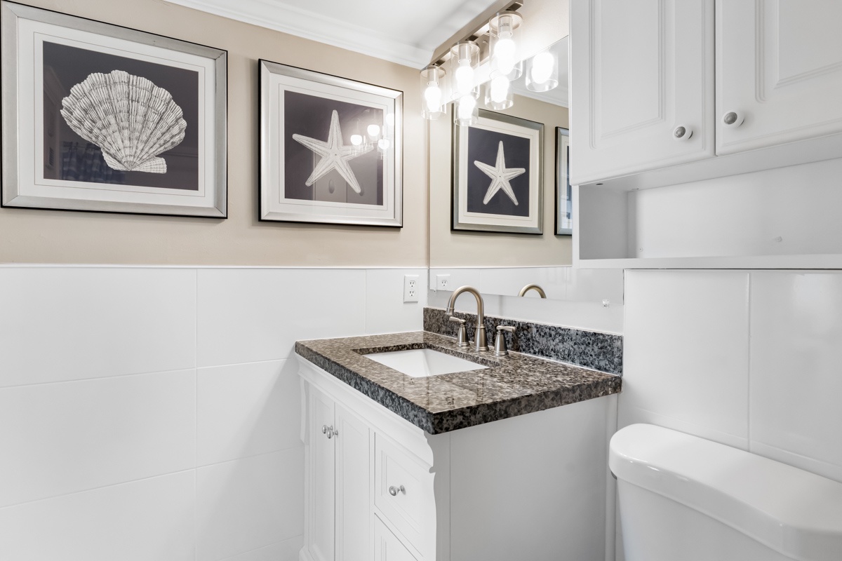 Your coastal-themed bathroom features elegant granite counters and charming seaside artwork, creating a serene retreat for your morning and evening routines.