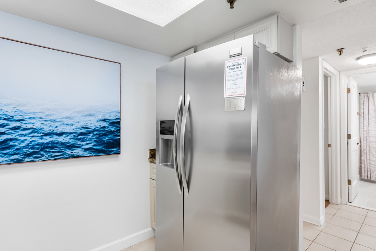 This bright kitchen features a spacious stainless-steel refrigerator with plenty of storage for your favorite meals and snacks, making it easy to settle in and feel at home.