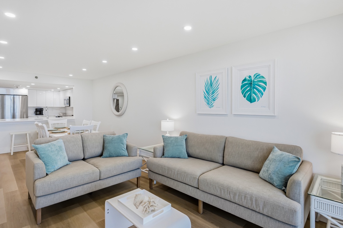 Relax in your bright, modern living space with coastal-inspired decor and comfortable seating that flows seamlessly into the dining area.