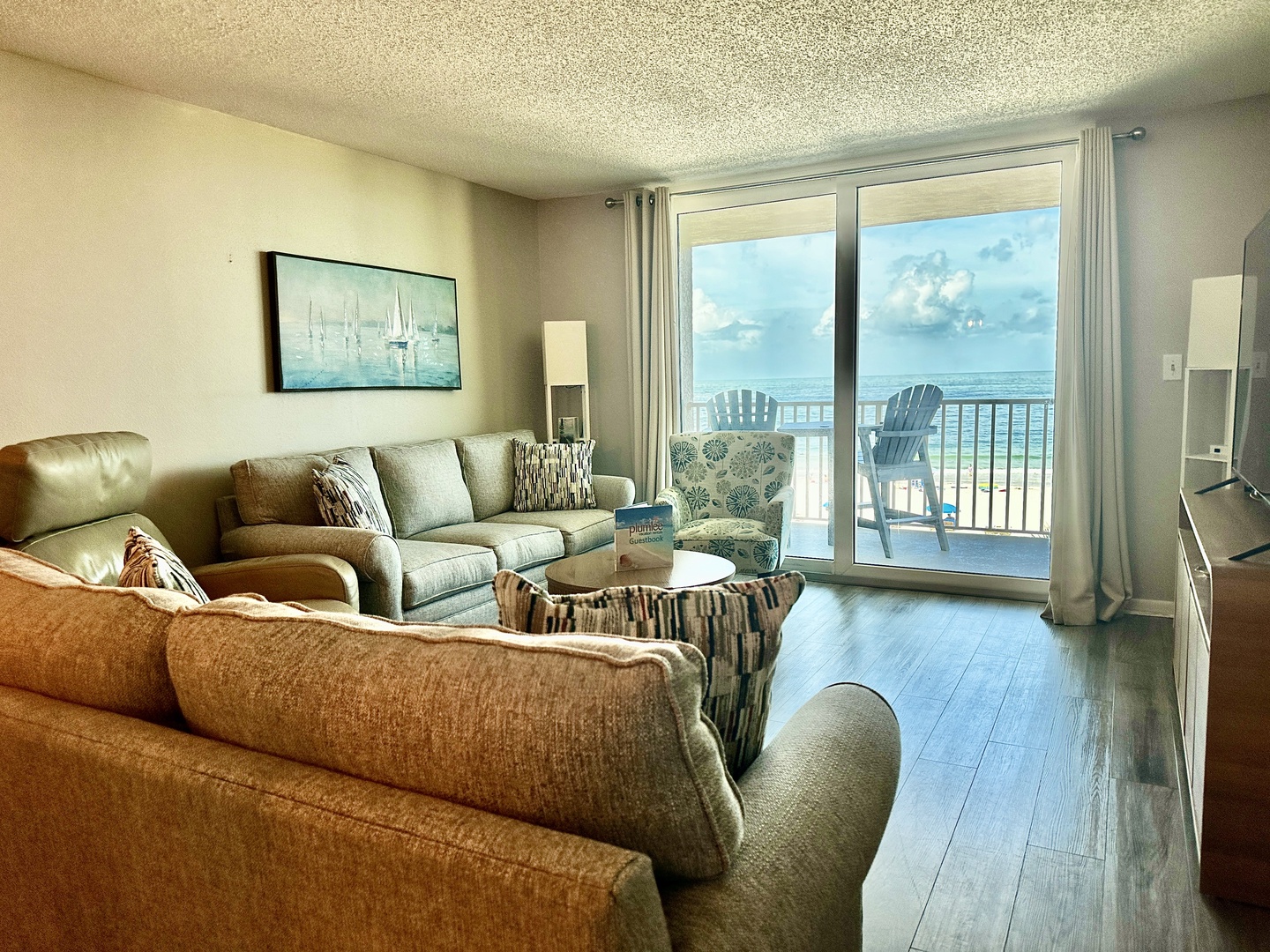 Imagine lounging in your bright, beachy living room where plush seating and coastal décor frame stunning ocean vistas just beyond your private balcony—your perfect coastal escape.