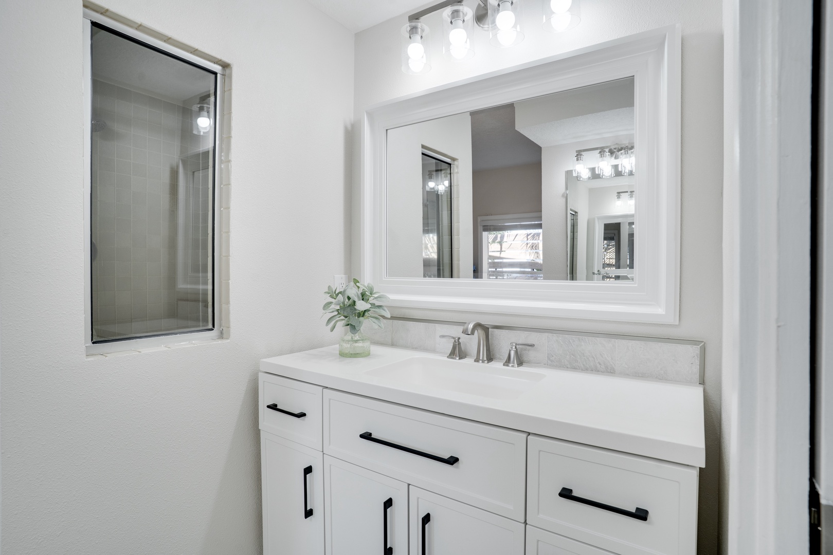 Your beautifully appointed bathroom features elegant vanity lighting, pristine white cabinetry, and thoughtful details that make your morning routine a pleasure.