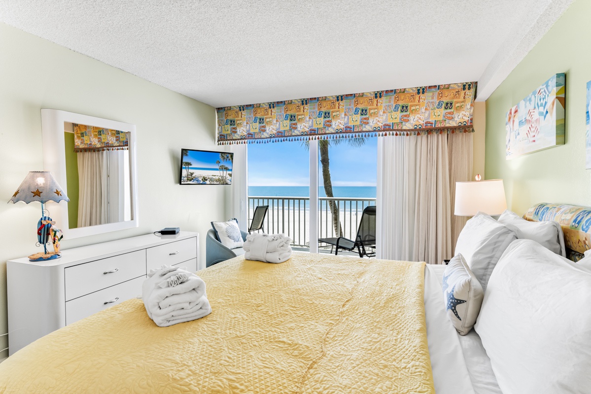 Wake up to stunning oceanfront views from your private balcony. This bright, cheerful bedroom offers a peaceful retreat with coastal-inspired decor, crisp linens, and a serene palette that invites relaxation.