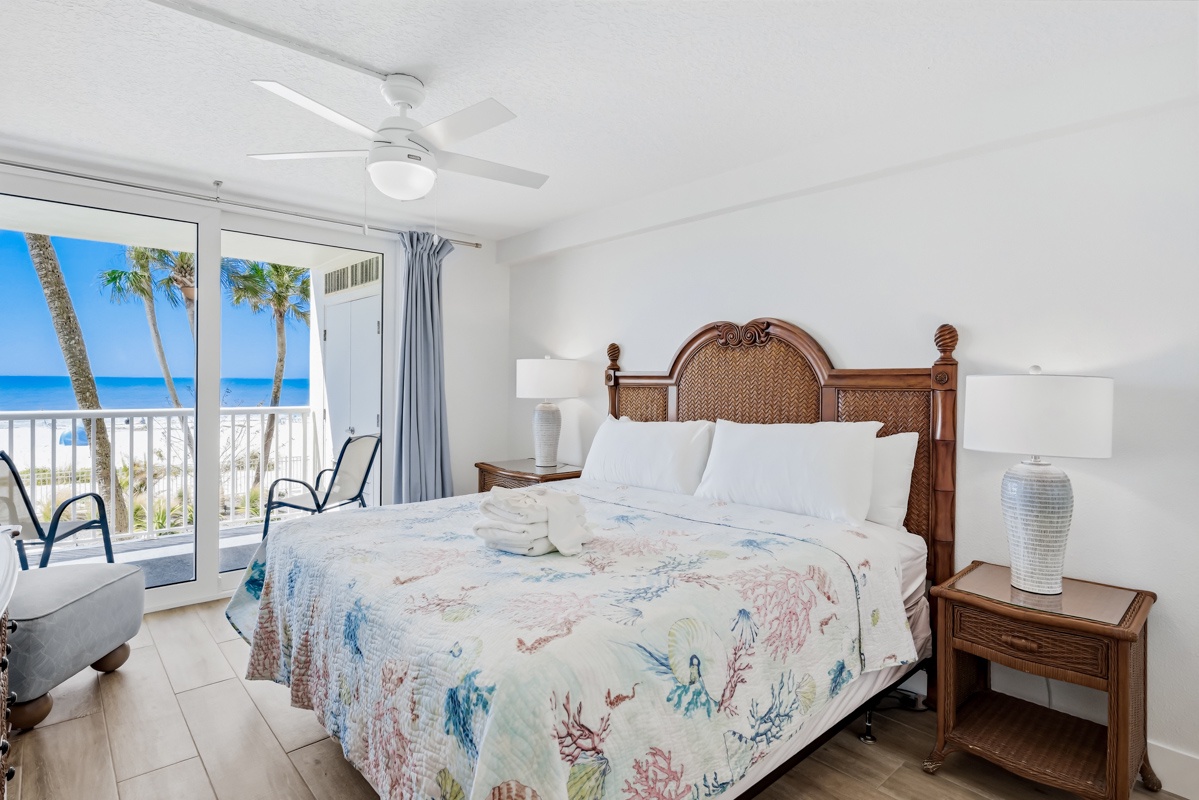 Your oceanfront bedroom offers stunning sea views through sliding doors leading to your private balcony. Relax beneath the ceiling fan with tropical breezes.