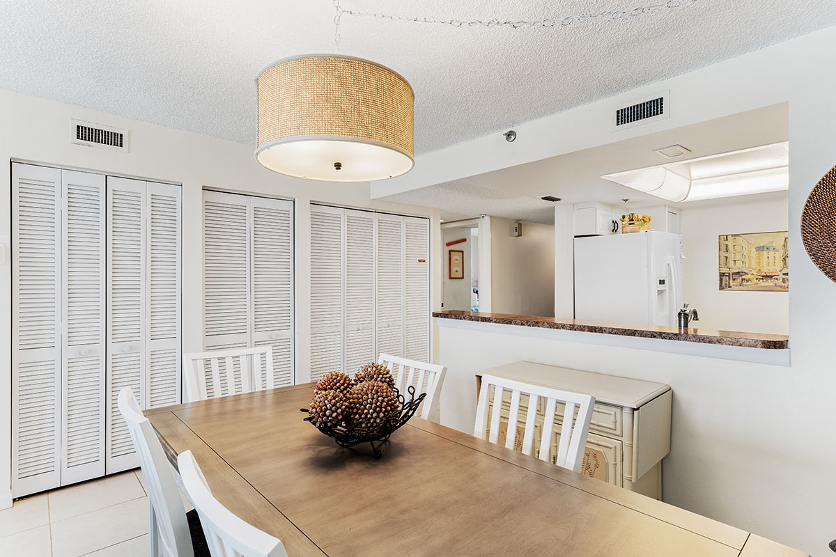 Gather around your elegant dining table where warm wood meets coastal charm, creating the perfect spot for memorable meals together.