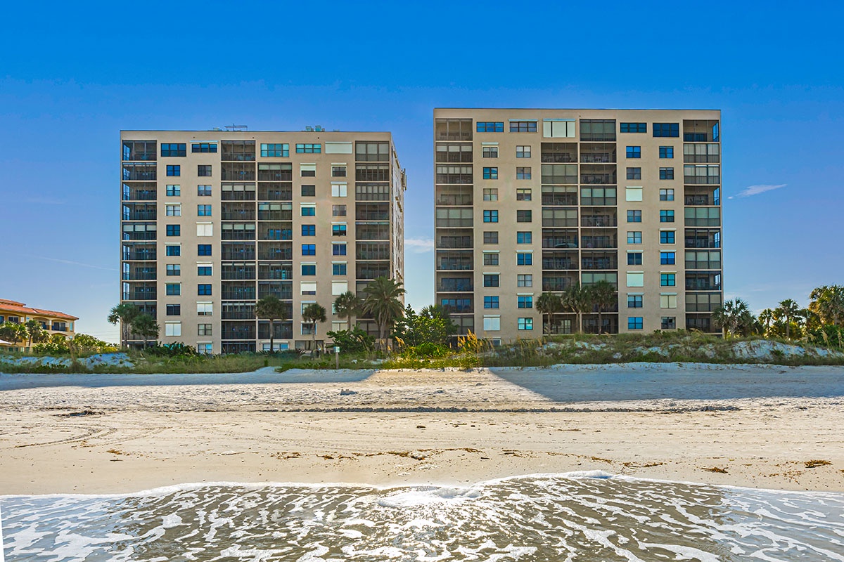 Beachfront property towers rise directly from pristine sandy shores with gentle waves lapping at your doorstep.