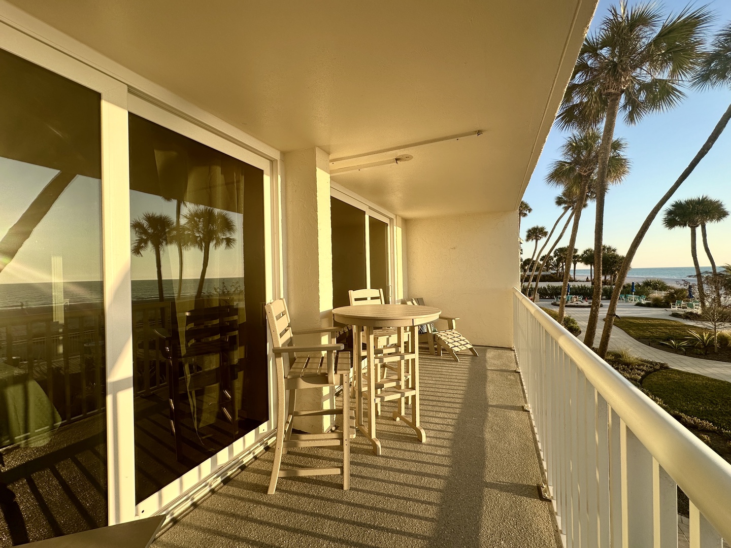 Your private balcony offers stunning ocean views through swaying palms, perfect for morning coffee or sunset cocktails.